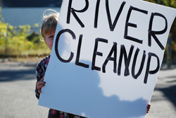 Sadie holding the River Cleanup sign
