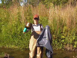Stephanie ready with trash in one hand and a nearly empty bag in the other