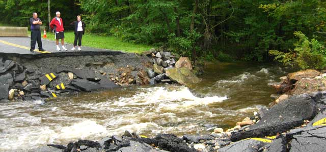 People Looking At A Stream Where There Once Was A Road